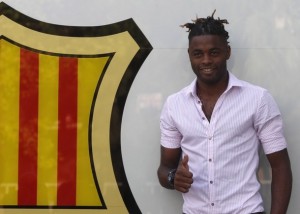 Barcelona's new player Alex Song poses for photographers after signing for five years at Nou Camp stadium in Barcelona
