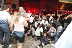 Policeman and rescue workers help a man in front of Kiss nightclub in the southern city of Santa Maria