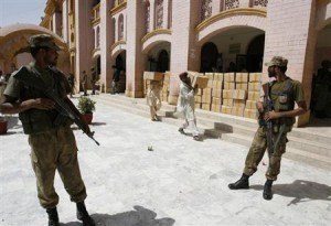 Soldiers stand guard outside a district court as election commission workers carry election materials in Hyderabad