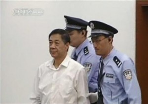 Still image of Bo Xilai being escorted into court by two police officers during his trial in Jinan