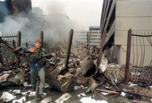 A U.S. embassy official secures the area around the embassy building after a powerful bomb blast in Nairobi