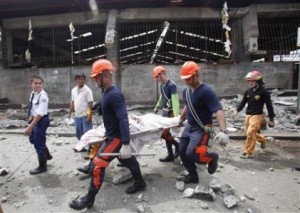 Rescue members recover the body of a vendor killed after an earthquake hit Pasil market in Cebu City