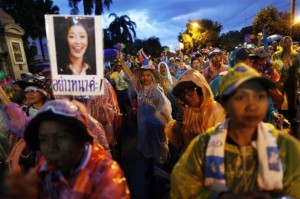 Anti-government protesters wear colourful rain protection gear as they block the road outside the Interior Ministry in Bangkok
