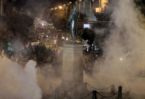 Tear gas fired by riot police at protesters fill the air during clashes at Talaat Harab square in downtown Cairo