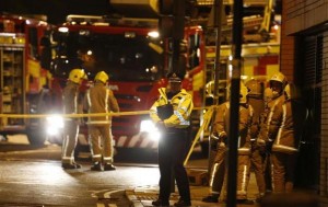 Rescue workers gather near the scene where a police helicopter crahed onto the roof of a pub in Glasgow