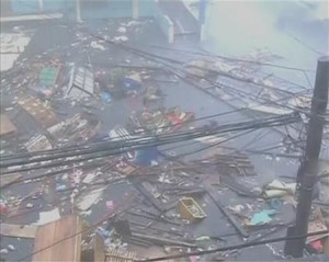 Debris float on a flooded road as strong winds and rain continue to batter buildings after Typhoon Haiyan hit Tacloban city, Leyte province