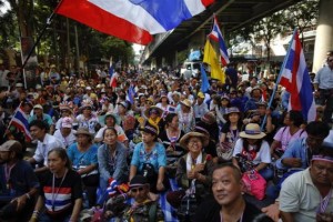 Anti-government protesters sit on the road outside the national police headquarters where they protest in Bangkok