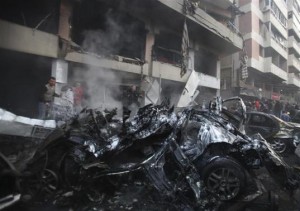 People attempt to extinguish a fire at the site of an explosion in Beirut's southern suburbs