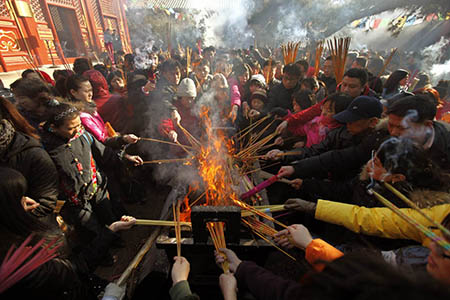 Locals burn incense to pray for good fortune on the first day of the Chinese Lunar New Year at Yonghegong Lama Temple in Beijing