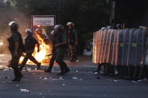 Riot police walk past a barricade of burning garbage during a protest against Venezuela's President Nicolas Maduro's government in Caracas