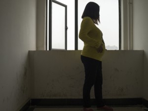 A rural woman going by her surname, Kong, six months pregnant acting as a surrogate, at the place she is staying in Wuhan, China.