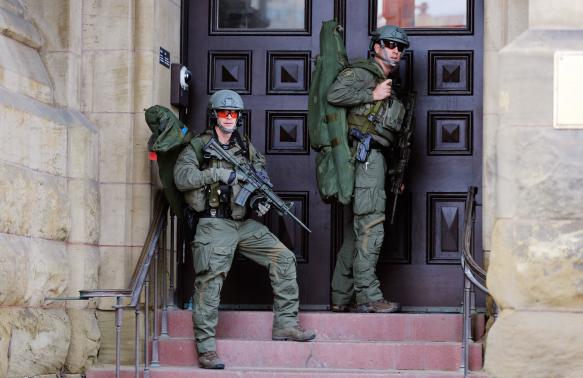 Armed RCMP officers guard the front of Langevin Block on Parliament Hilll following a shooting incident in Ottawa