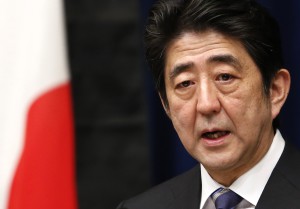 File photo Japan's PM Shinzo Abe speaking next to the national flag, which is hung with a black ribbon as a symbol of mourning for victims of the March 11, 2011 earthquake and tsunami, in Tokyo