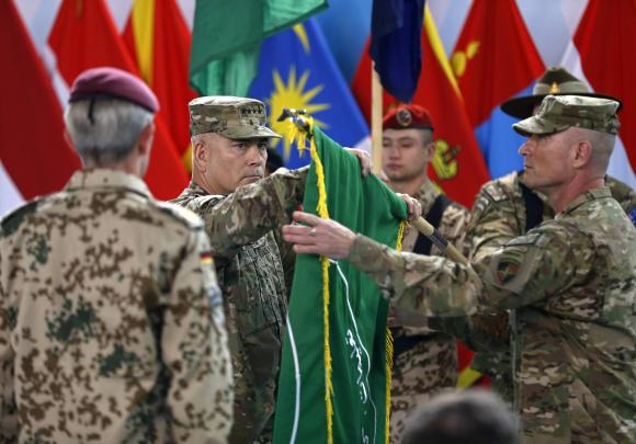 U.S. General John Campbell, commander of NATO-led International Security Assistance Force (ISAF), folds the flag of the ISAF during the change of mission ceremony in Kabul