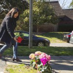 A woman places flowers near a building where three young Muslims were killed on Tuesday, in Chapel Hill, North Carolina