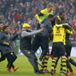 Bayern Munich's Neuer walks past Borussia Dortmund players celebrating winning the German Cup semi-final soccer match in Munich