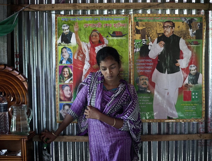 ၂။ ဒီပံုကေတာ့ မူဆာမက္အာခီအာ့က္တာရဲ႕အိမ္မွာ ဘဂၤလားေဒ့ရွ္ႏိုင္ငံ၀န္ႀကီးခ်ဳပ္ ရွိတ္ခ္ဟာ ဆီနာနဲ႔ သူ႕ရဲ႕ဖခင္ ဘဂၤလားေဒ့ရွ္ႏိုင္ငံေခါင္းေဆာင္ ရွိတ္ခ္မူဂ်ဘာရာမန္ တို႔ရဲ႕ပံုေတြနားမွာ ရိုက္ထားတဲ့ပံုပါ။ (ဓာတ္ပံု - theguardian.com)