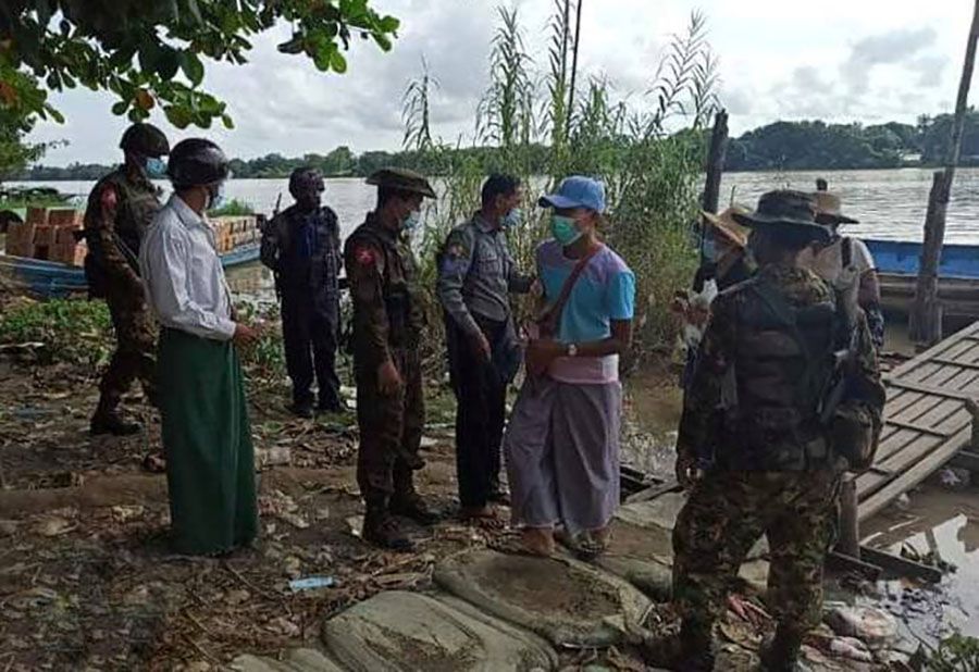 ငပုတောမြို့နယ်က စက်လှေဆိပ်ကမ်းတခုတွင် စစ်ဆေးနေသည့် စစ်သားနှင့် ရဲတပ်ဖွဲ့ဝင်အချို့။ (Photo: Myo Min)