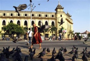 A Buddhist monk walks past the City Hall in downtown Yangon