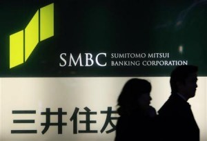 People walk past a signboard of Sumitomo Mitsui Banking Corporation in Tokyo